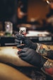 person in black leather gloves holding black and white lego toy