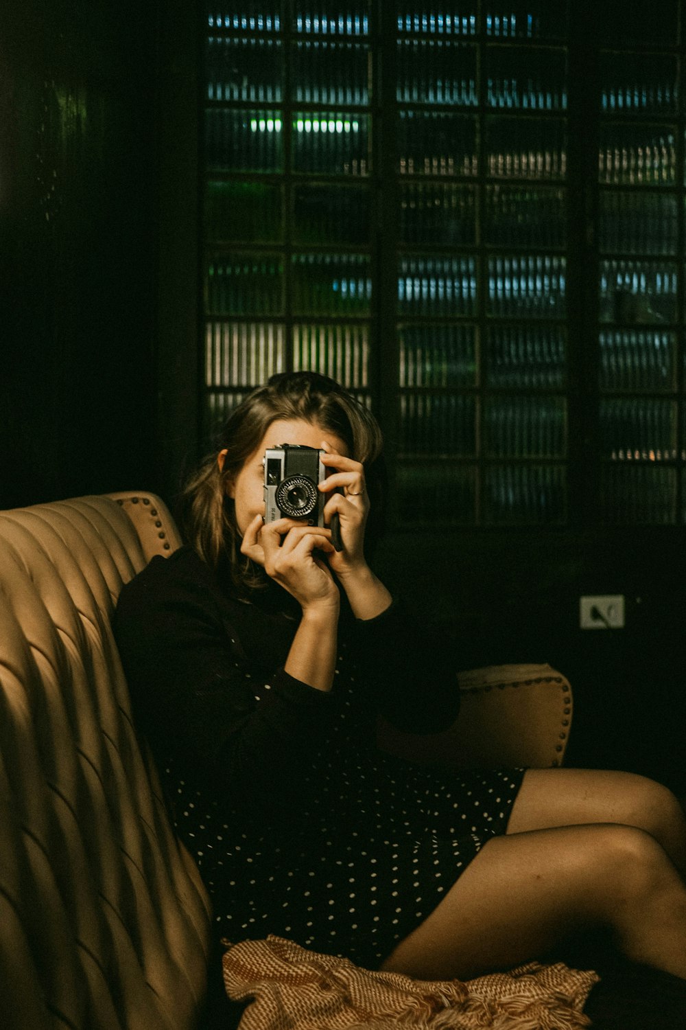 woman in black long sleeve shirt holding black and white camera