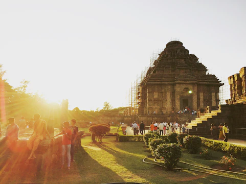 Ancient ruins bathed in warm light with visitors exploring the site.