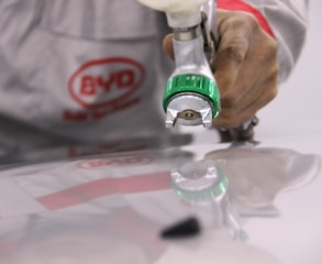 person holding green and white plastic bottle