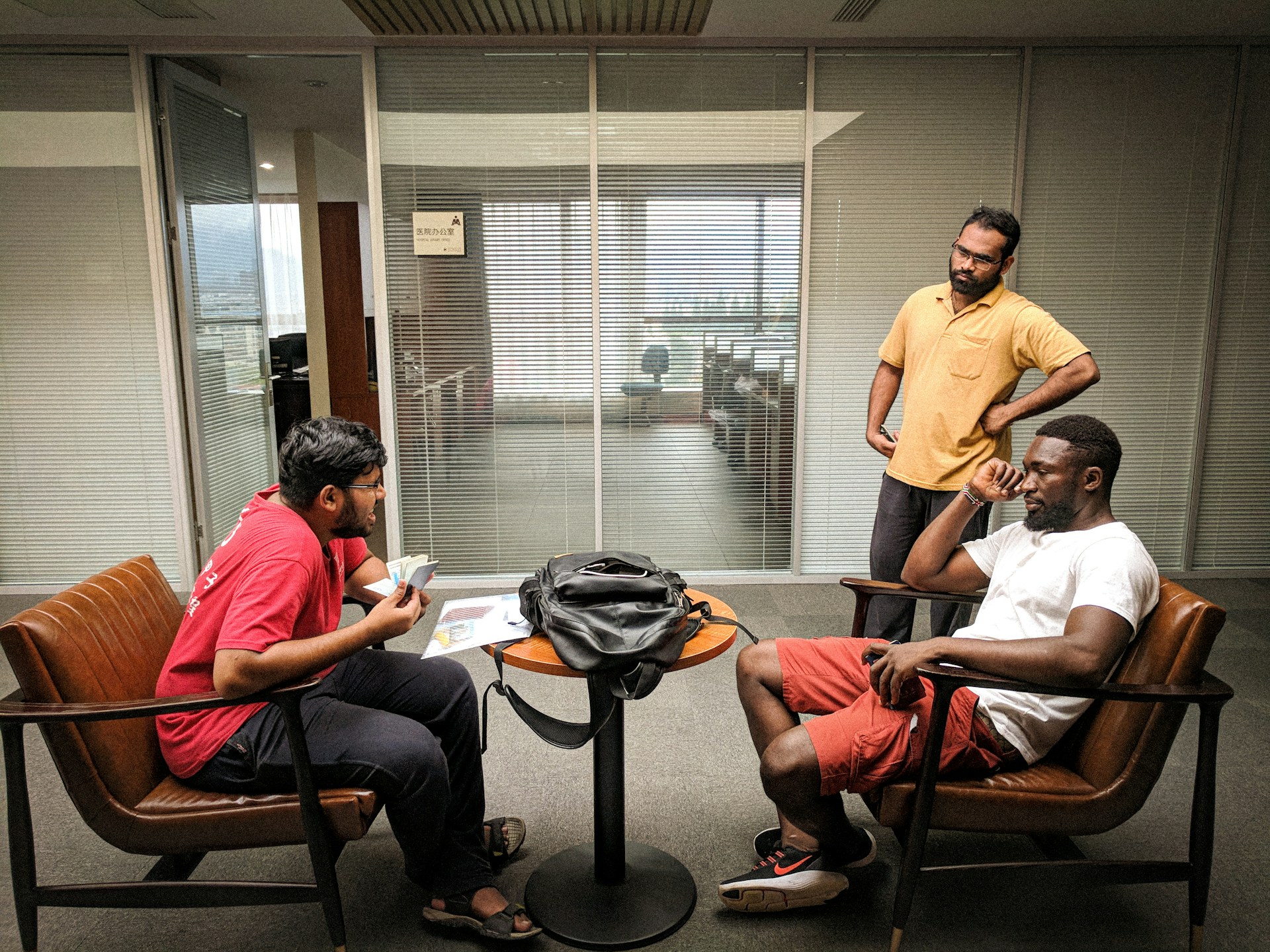 man in orange polo shirt sitting on brown wooden armchair