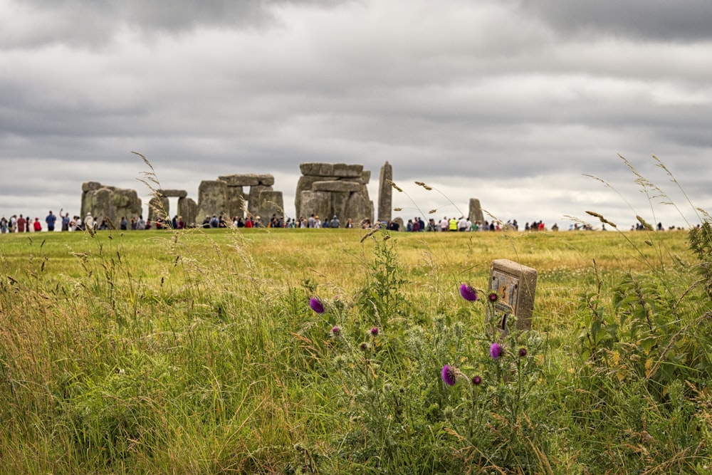 green grass field with rocks under white clouds during daytime