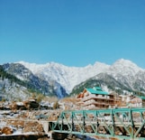 green wooden bridge over the mountains during daytime