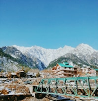 green wooden bridge over the mountains during daytime