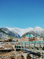 green wooden bridge over the mountains during daytime