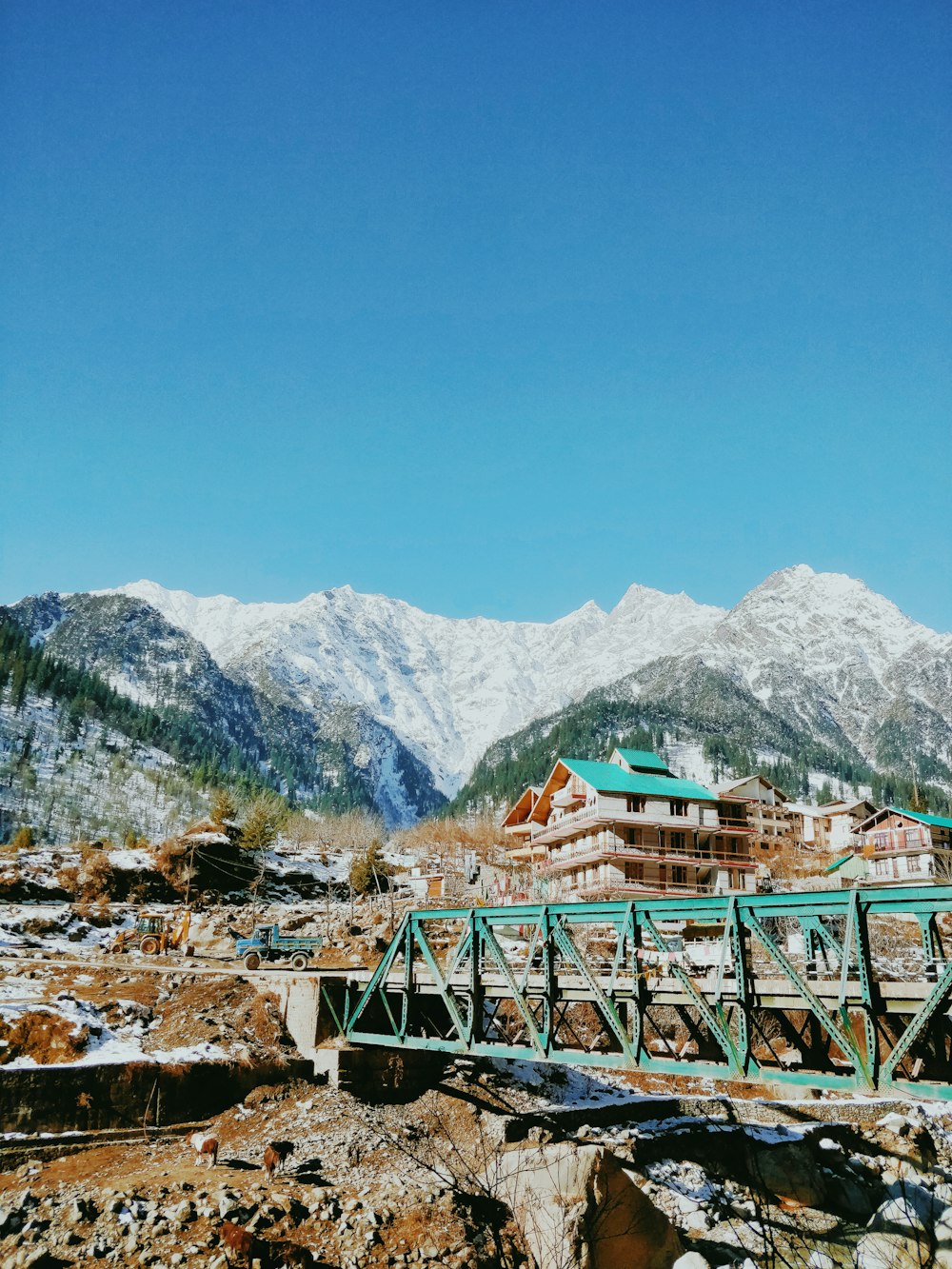 green wooden bridge over the mountains during daytime