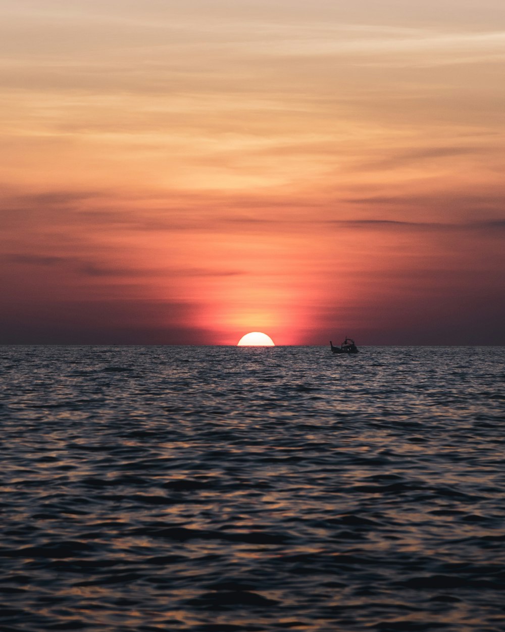 silhouette of person on body of water during sunset