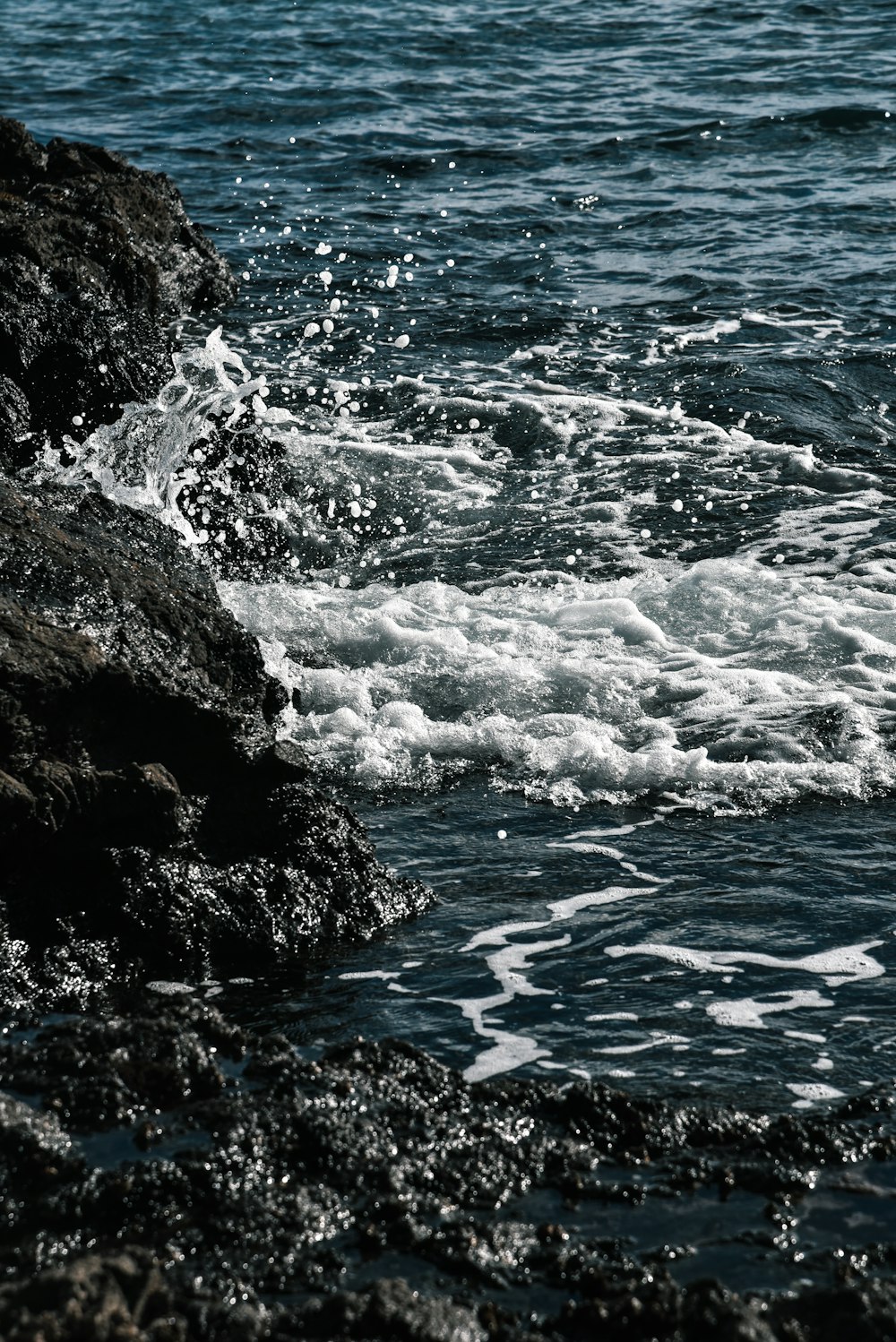 water waves hitting rock formation during daytime