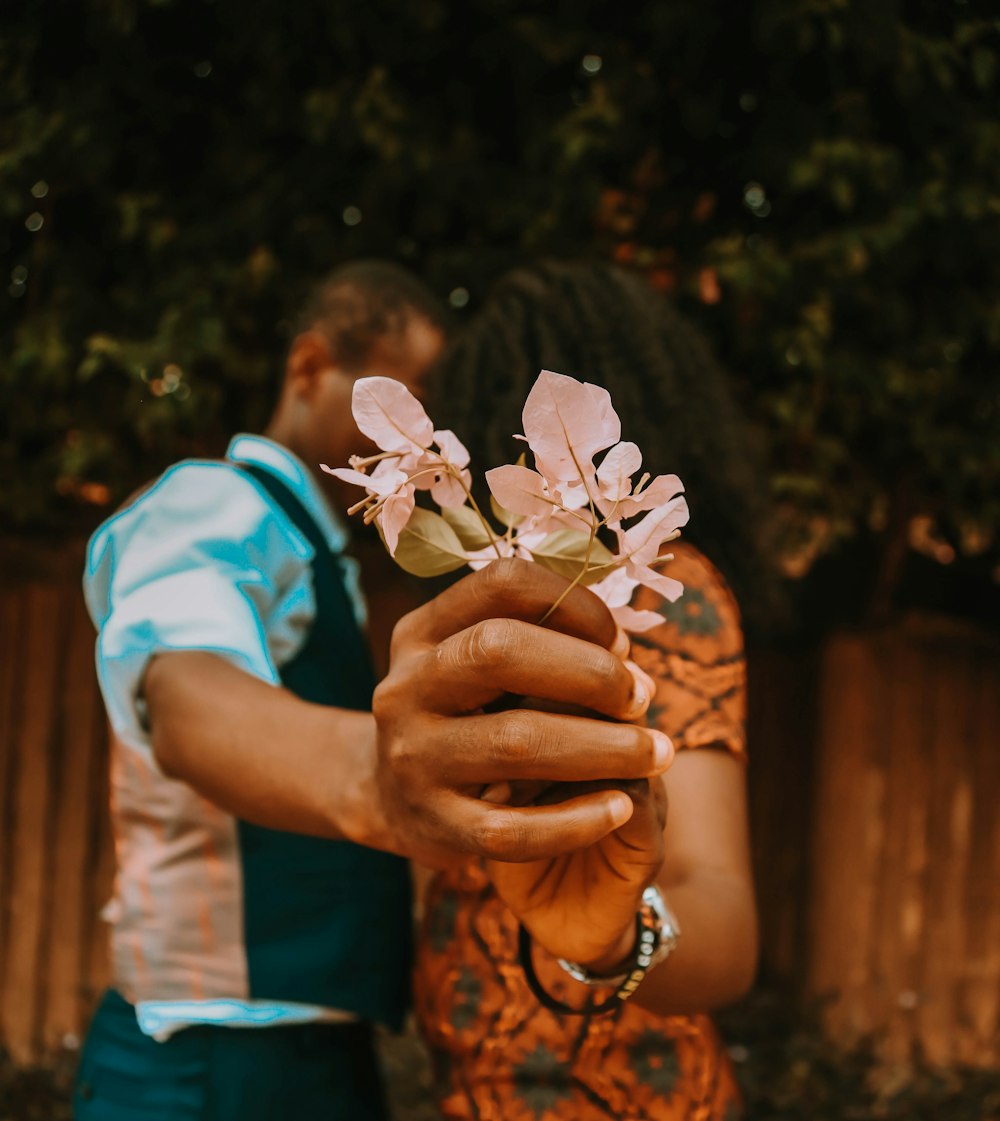 person holding white flower during daytime