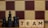 Wooden blocks with the word 'TEAM' are placed next to black chess pieces, including pawns and a king. The background features a blurred chessboard pattern with alternating light and dark squares.