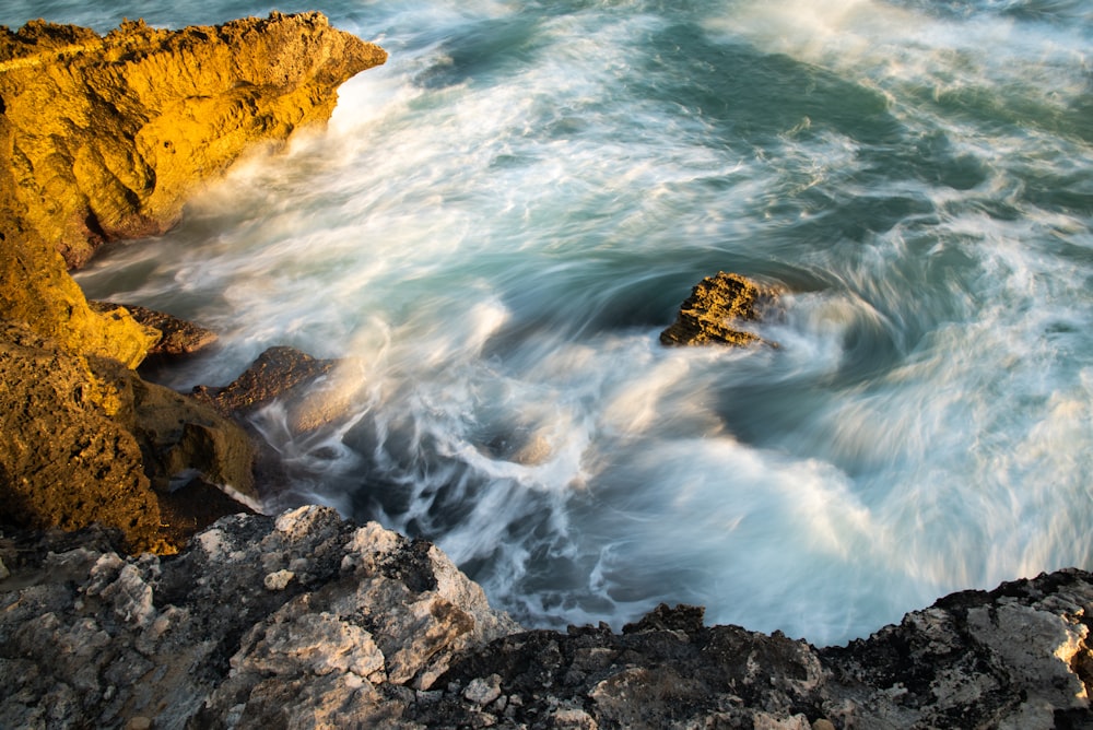 brown rock formation on sea water during daytime