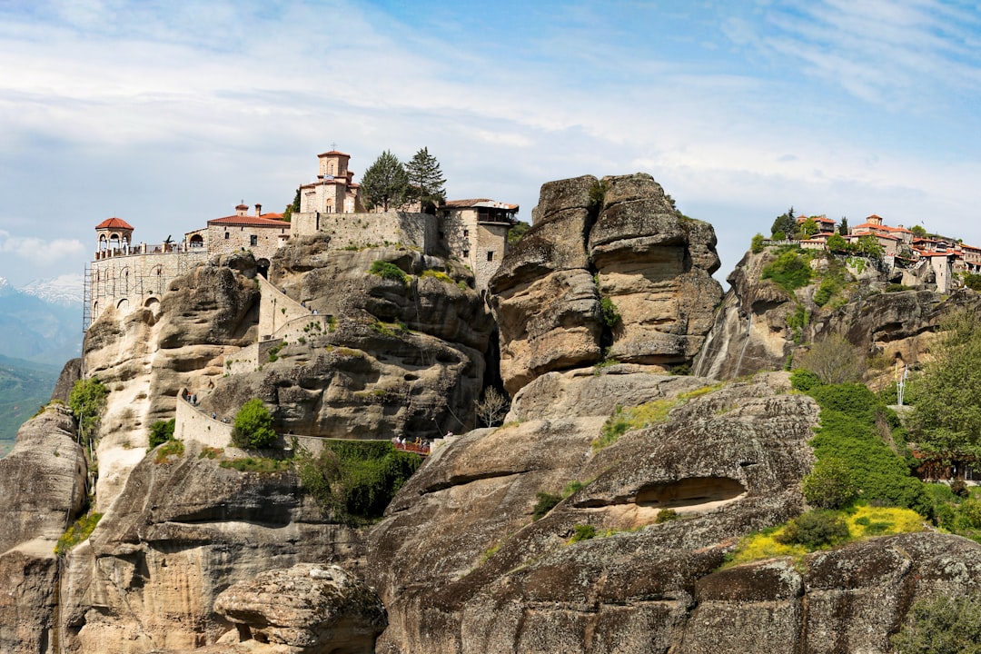 brown and gray concrete building on brown rocky mountain under blue sky during daytime