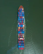 Large cargo ship sailing with colorful containers stacked high