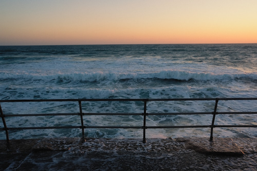 black metal fence on seashore during daytime