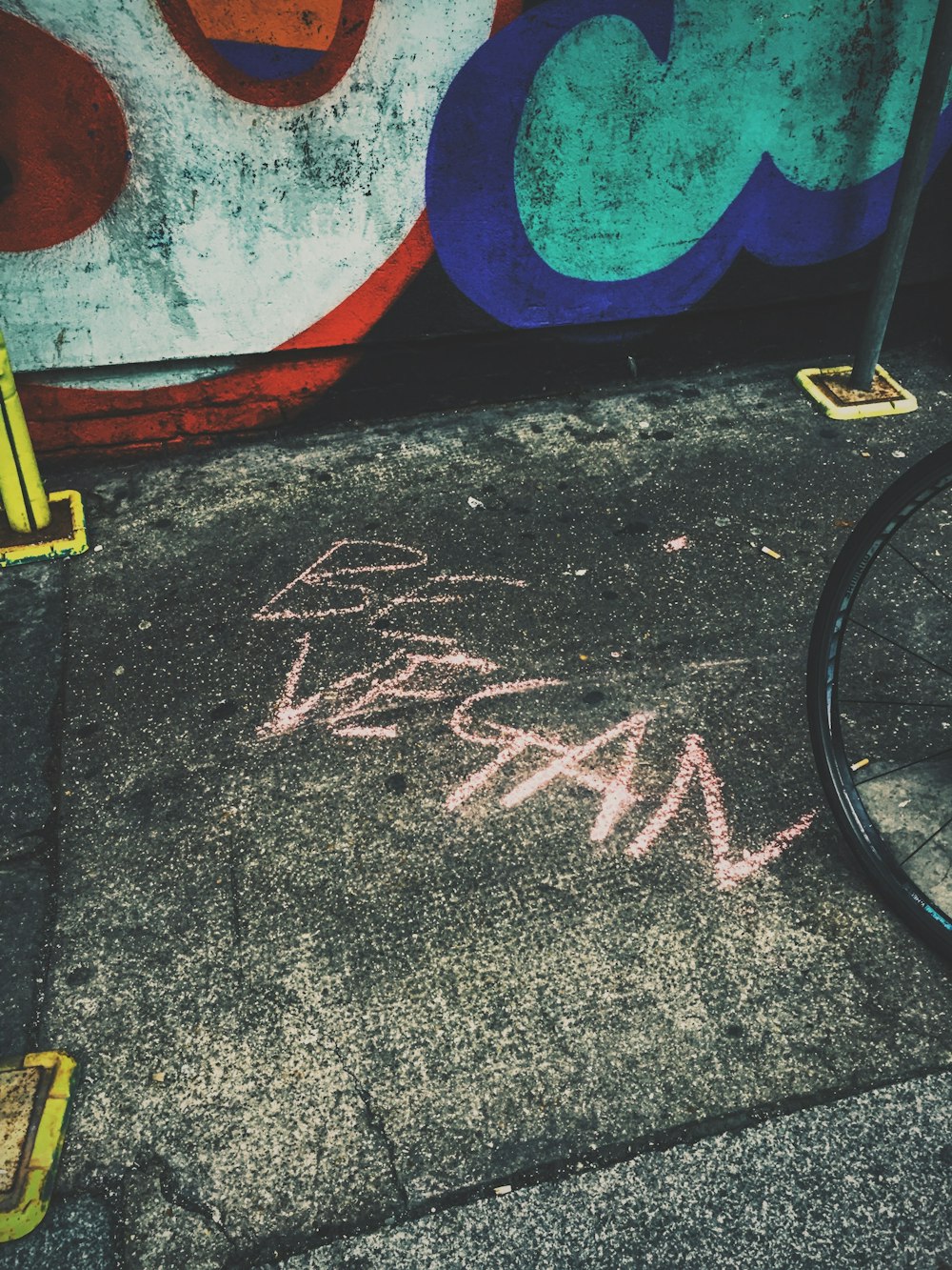 black bicycle wheel leaning on wall