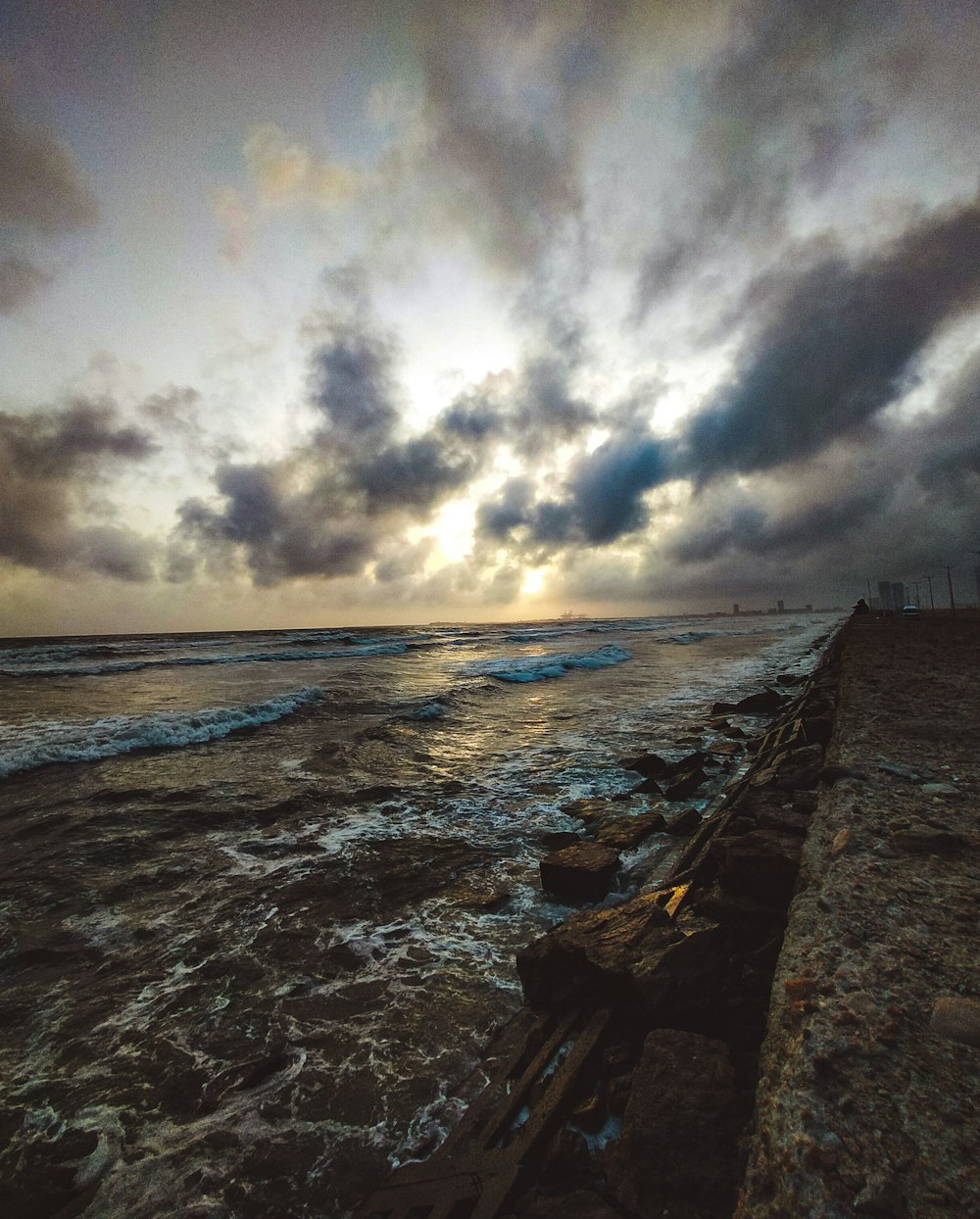 ondas do mar batendo na costa sob o céu nublado durante o dia