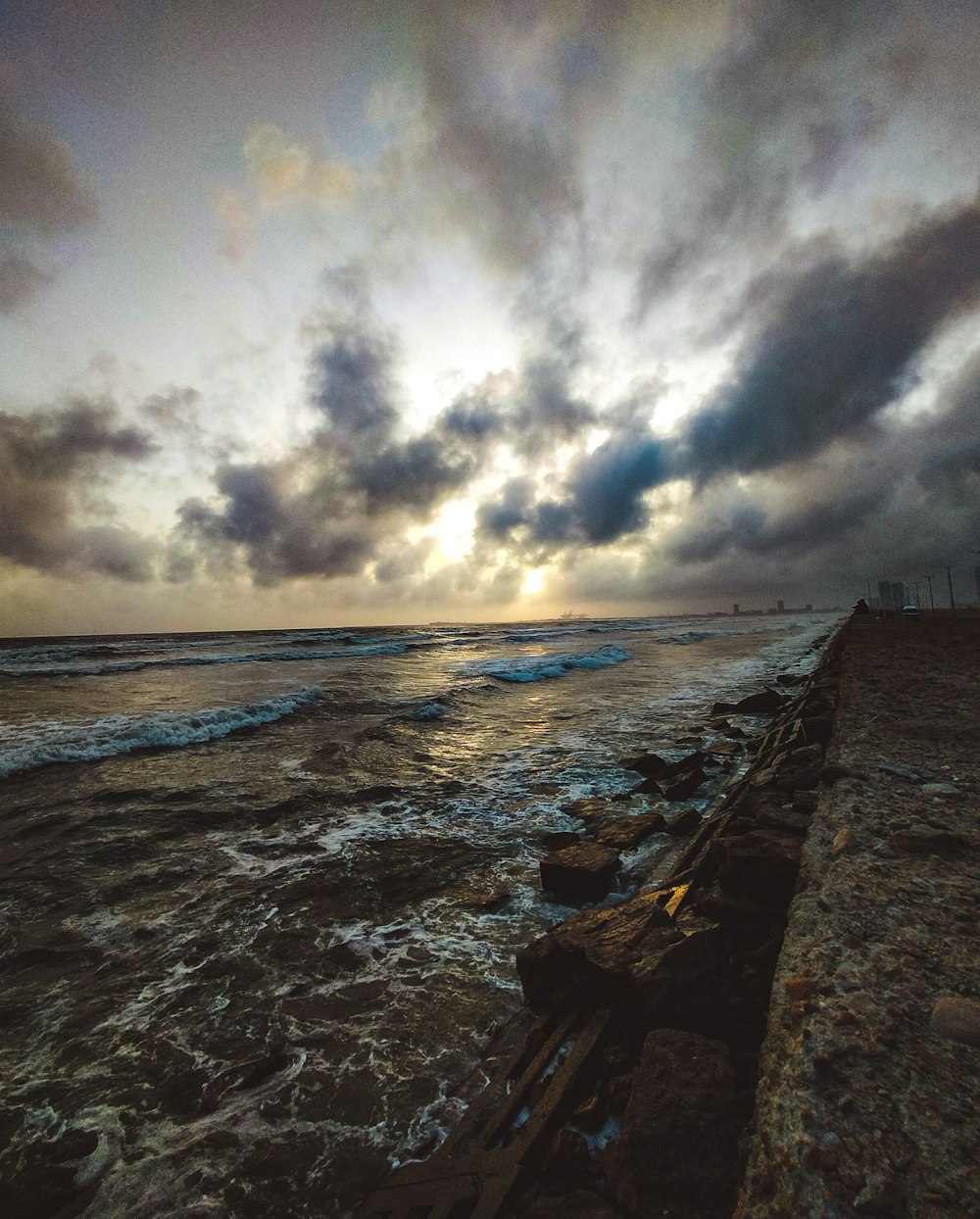 昼間曇り空の下、海岸に打ち寄せる波