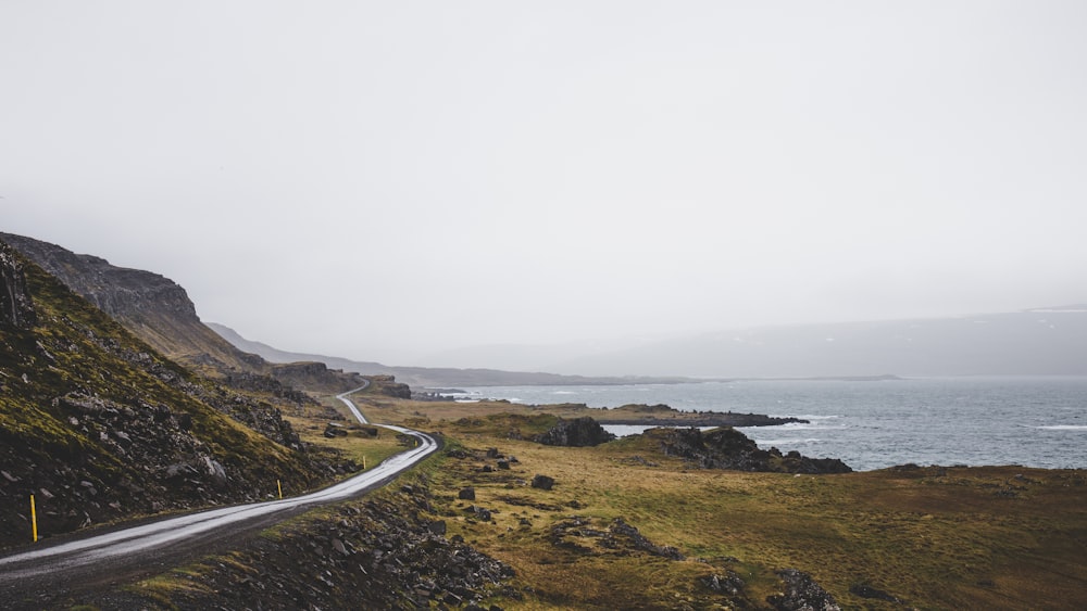 gray concrete road near green grass field during daytime