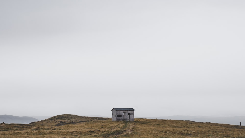 white wooden house on brown field under white sky during daytime