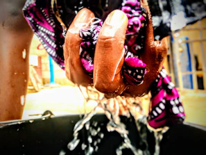 A fabric mouse pad being rinsed under running water to show easy cleaning.