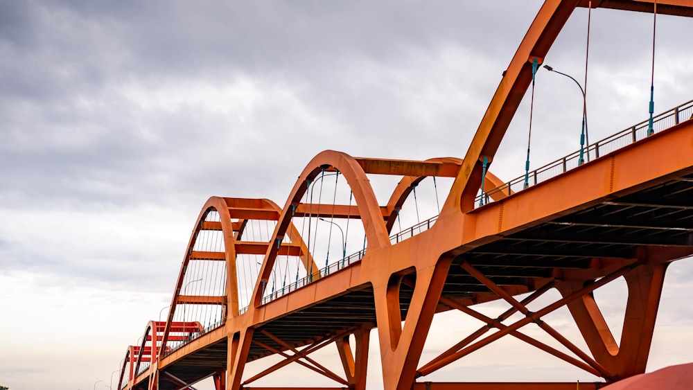 ponte de metal vermelho sob nuvens brancas durante o dia