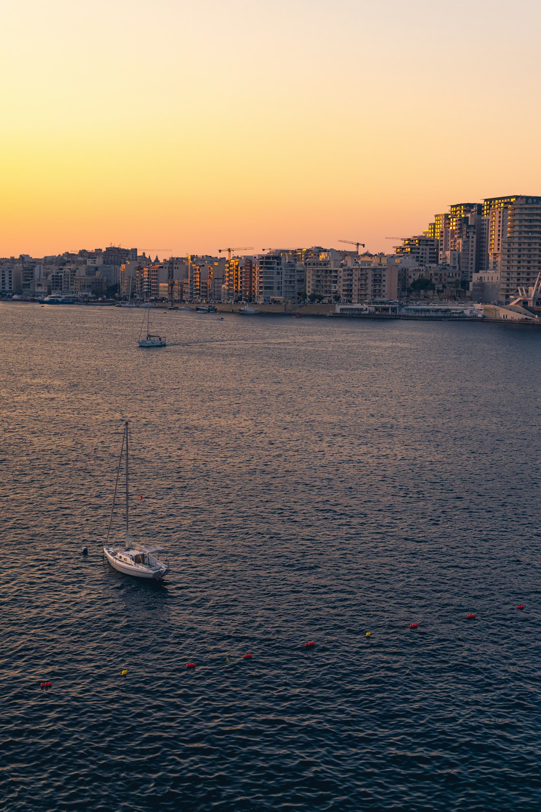 white boat on body of water near city buildings during daytime