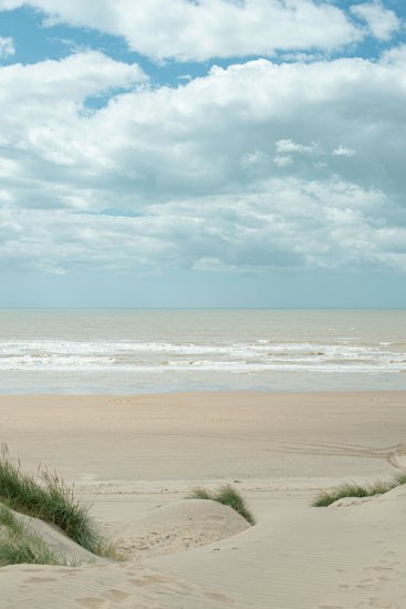 Wide empty sweep of sand under a big cloudy sky on the Northumberland coast