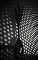 A tall, slender vase with a textured surface catching the sunlight.