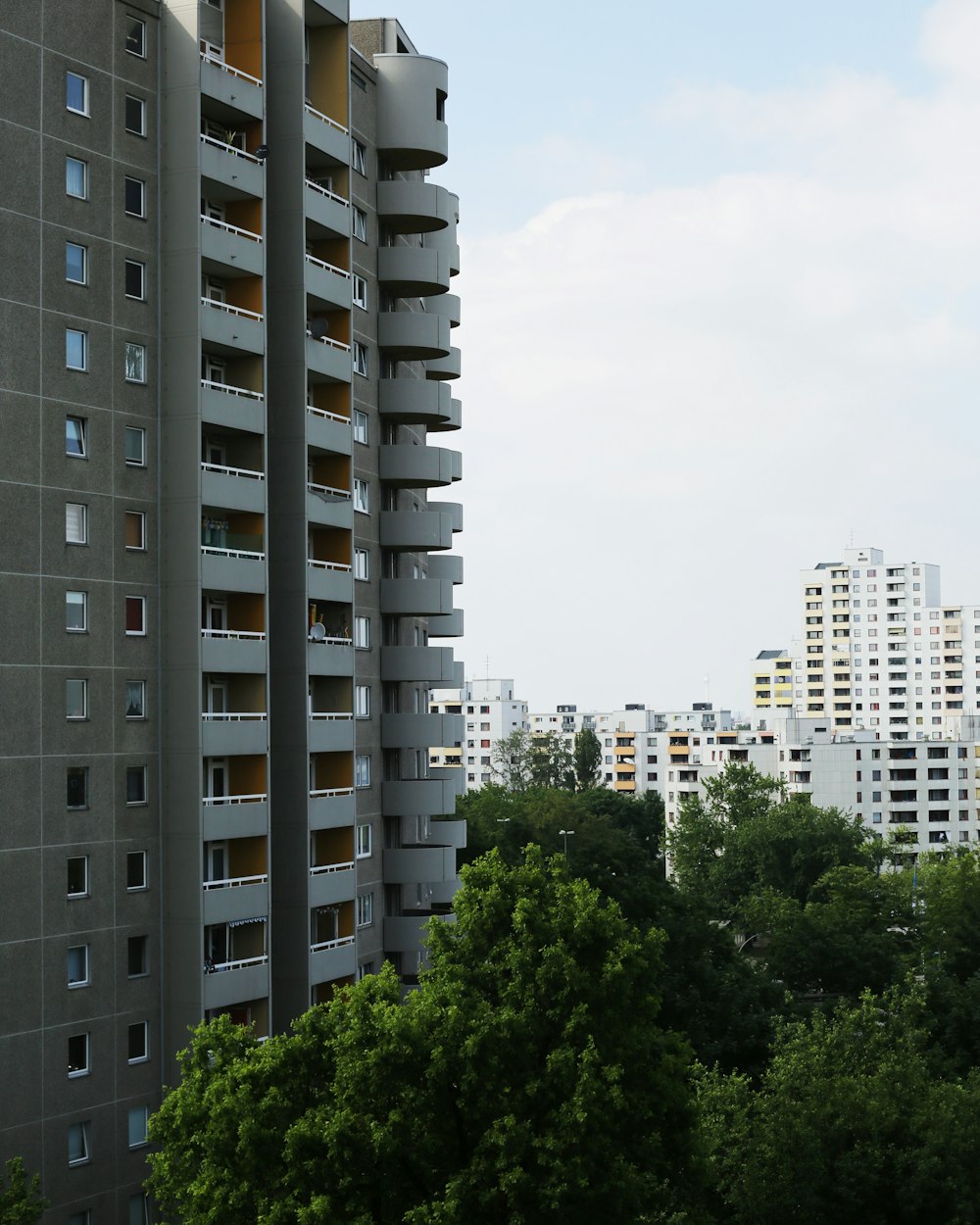 green trees near white concrete building during daytime