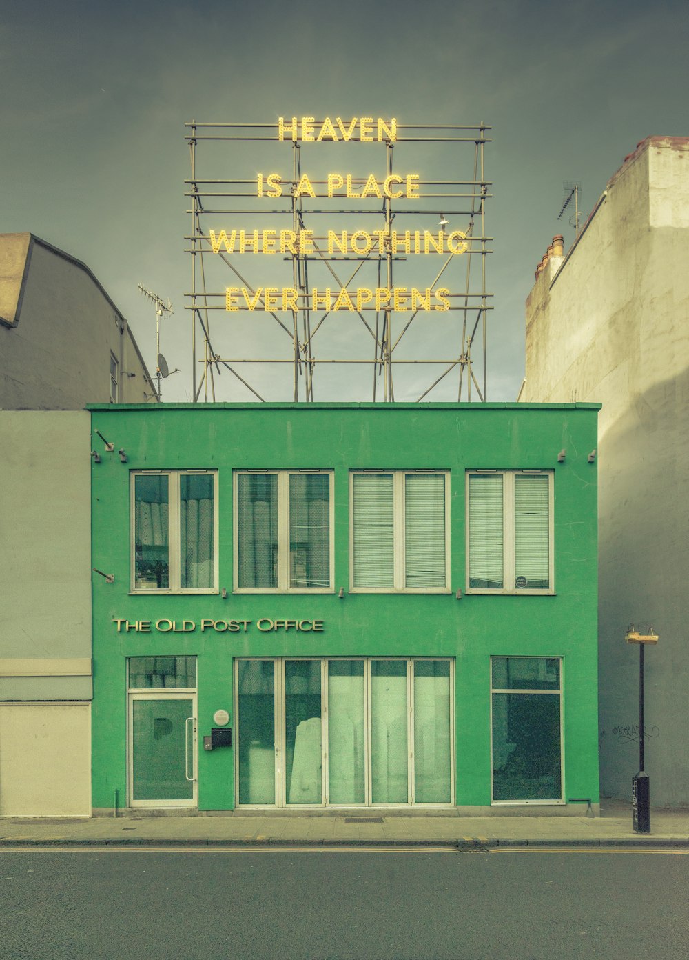 a green building with a neon sign that says heaven is a place where nothing ever