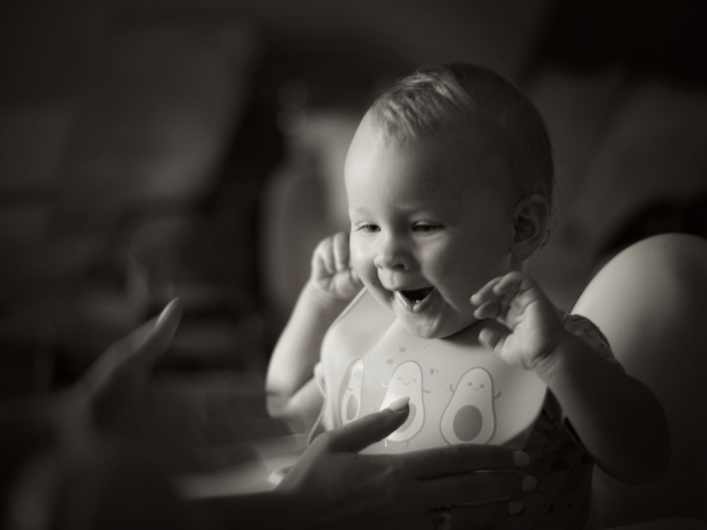 grayscale photo of baby in white tank top