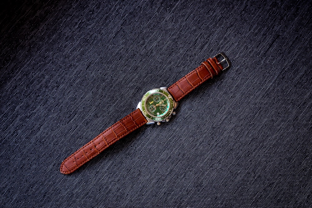 Reloj analógico redondo dorado con correa de cuero marrón