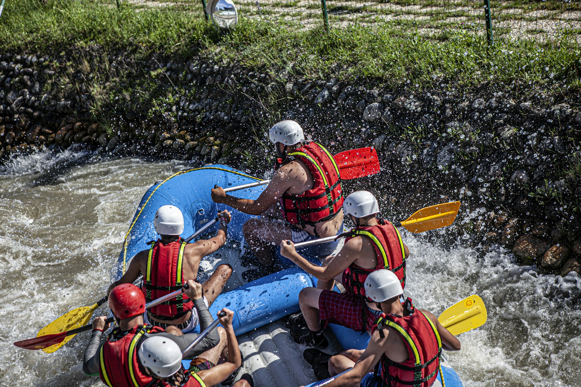2 men riding blue kayak on green grass during daytime