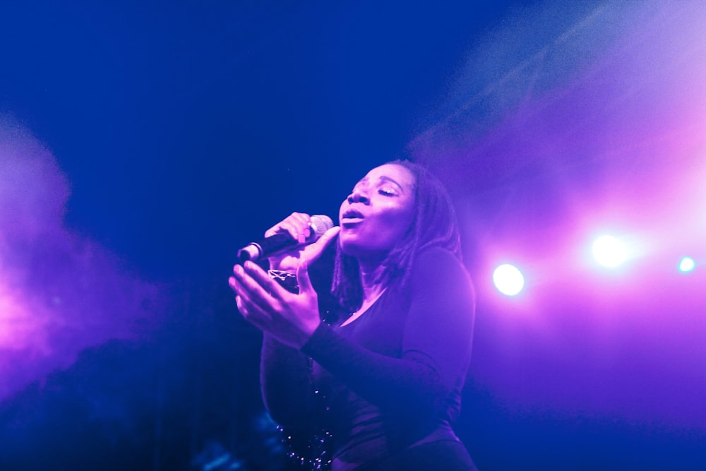 woman in black long sleeve shirt holding microphone