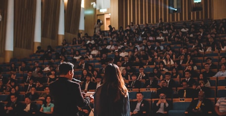 Best public speakers giving speech in front of people sitting in a hall