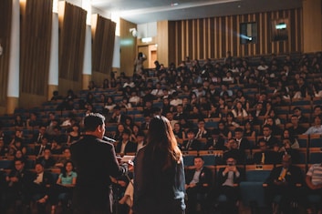 Best public speakers giving speech in front of people sitting in a hall