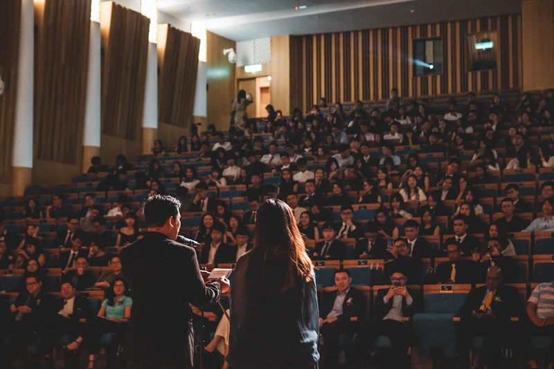A host addressing a full hall of guests during an awards evening