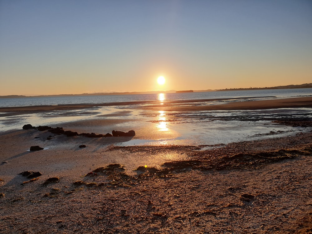 sea waves crashing on shore during sunset