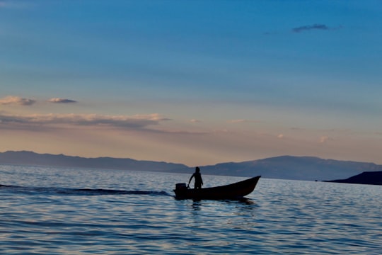 silhouette of man riding on boat during sunset in Urmia lake Iran