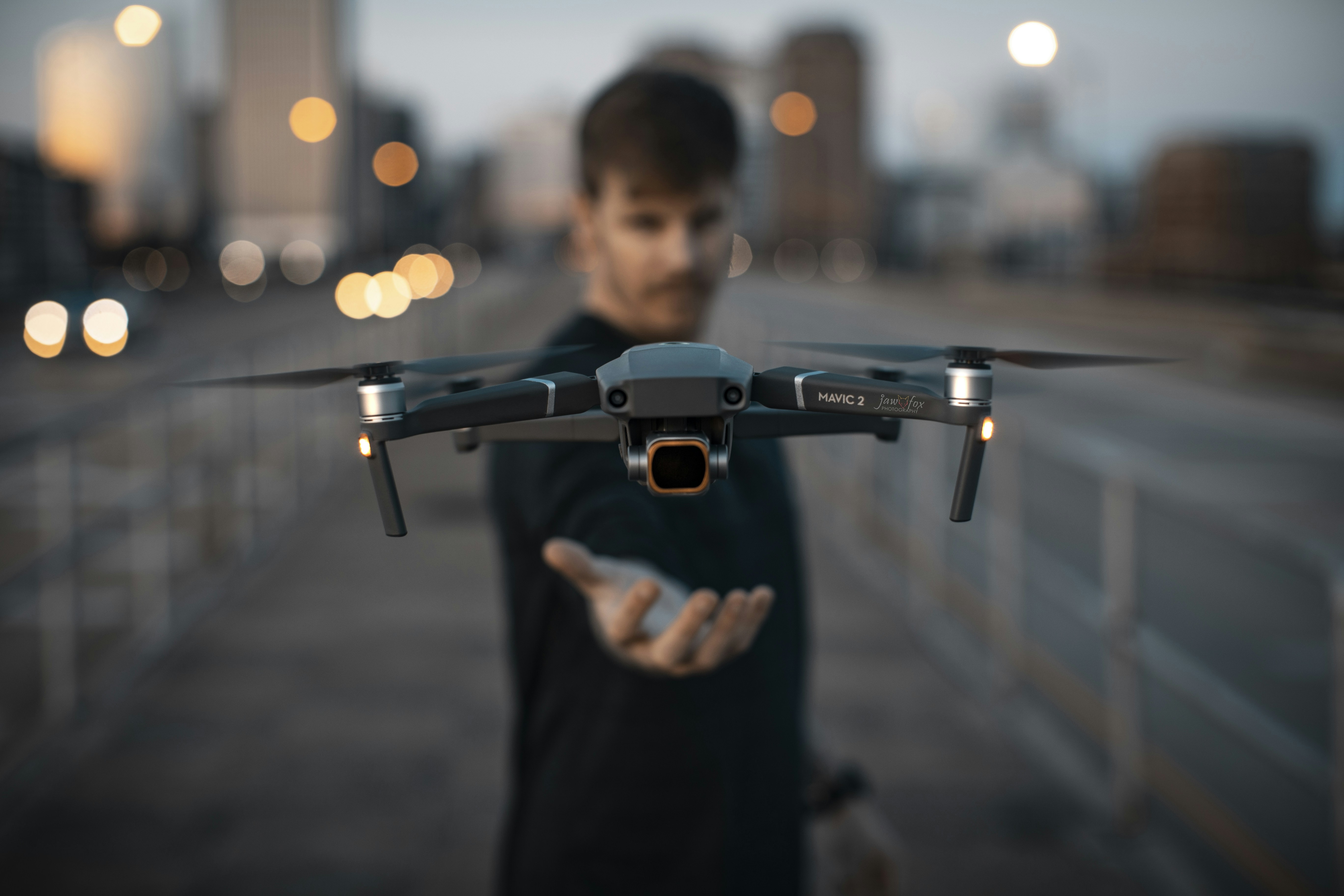 man in black shirt holding black and gray drone