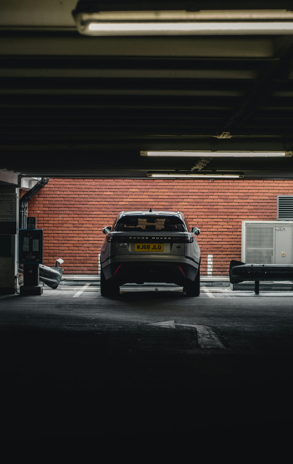 black and yellow car parked beside brown brick building