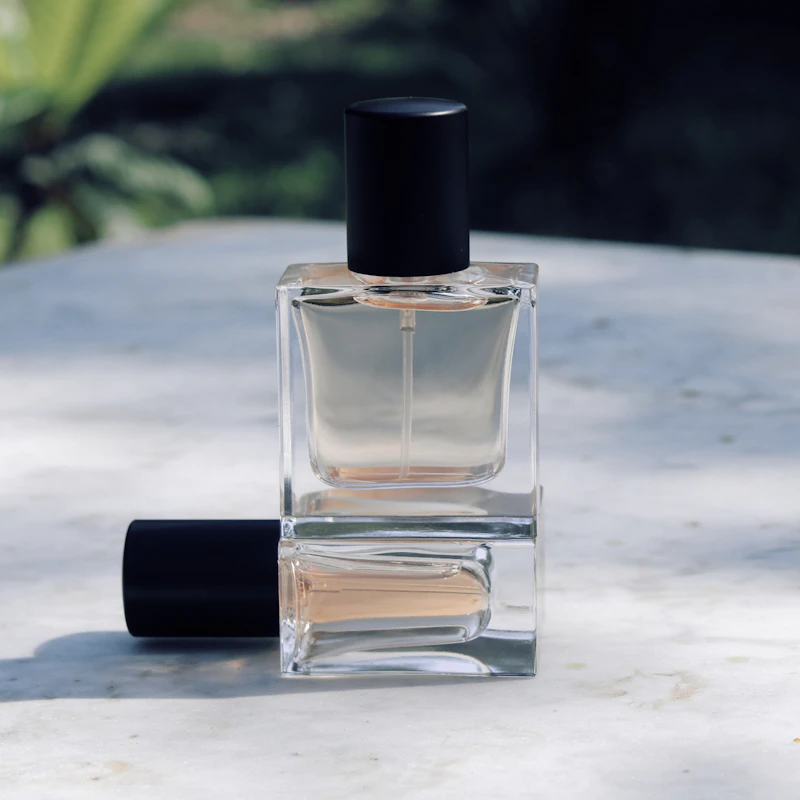 Minimal clear glass perfume bottle with black cap