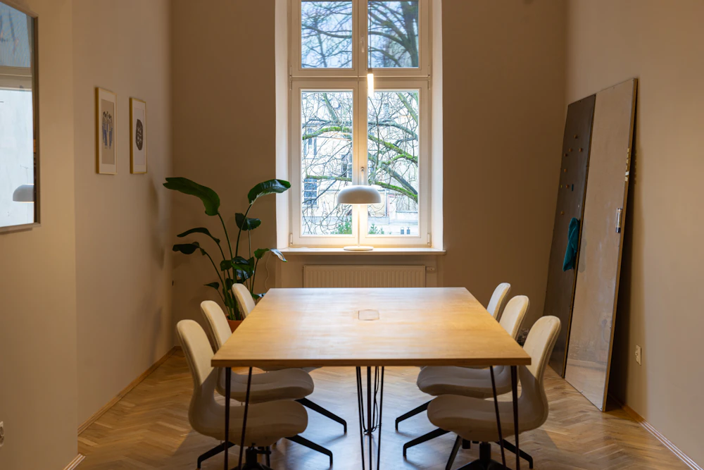 Sala de reuniones con mesa larga de madera y luz natural