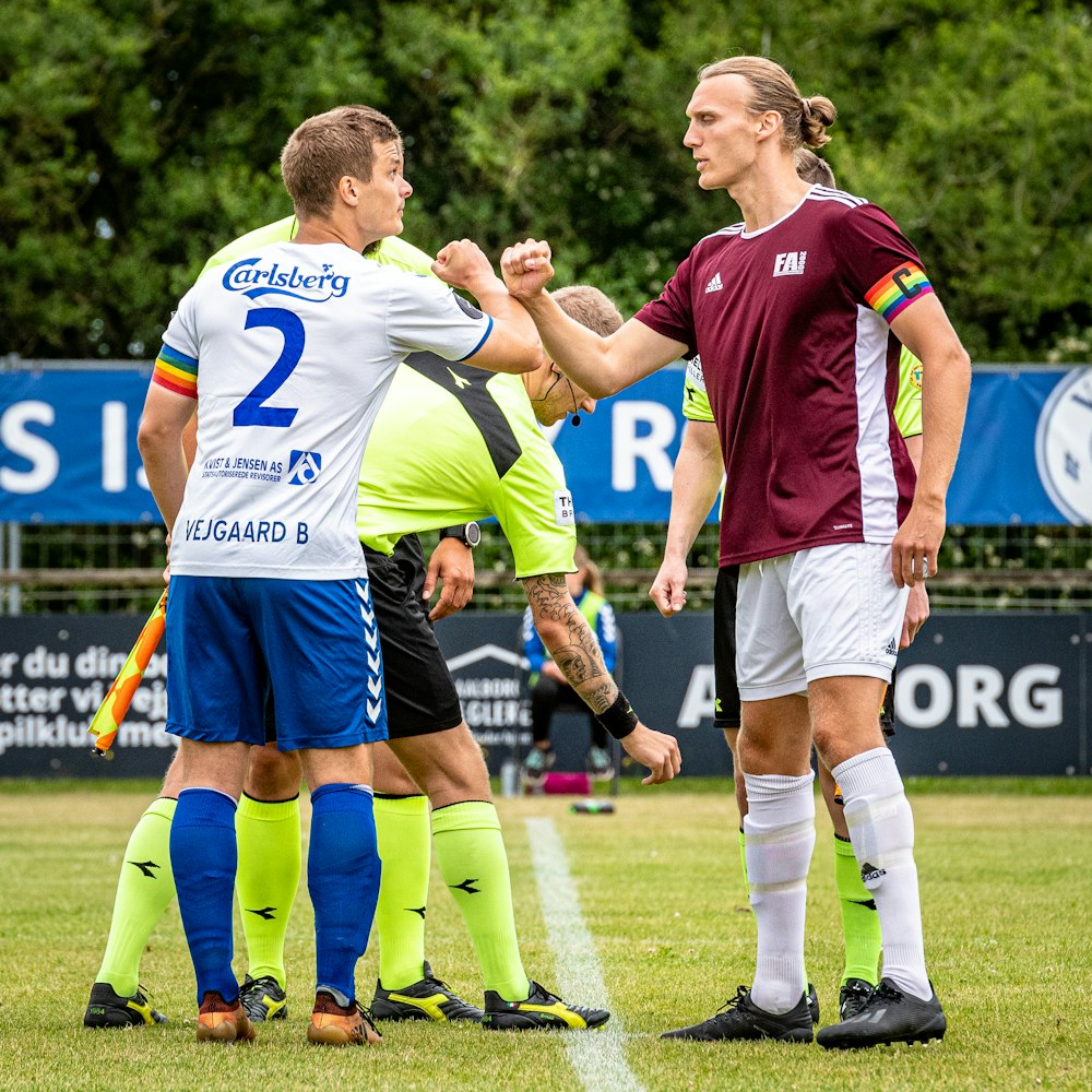 group of men playing soccer during daytime