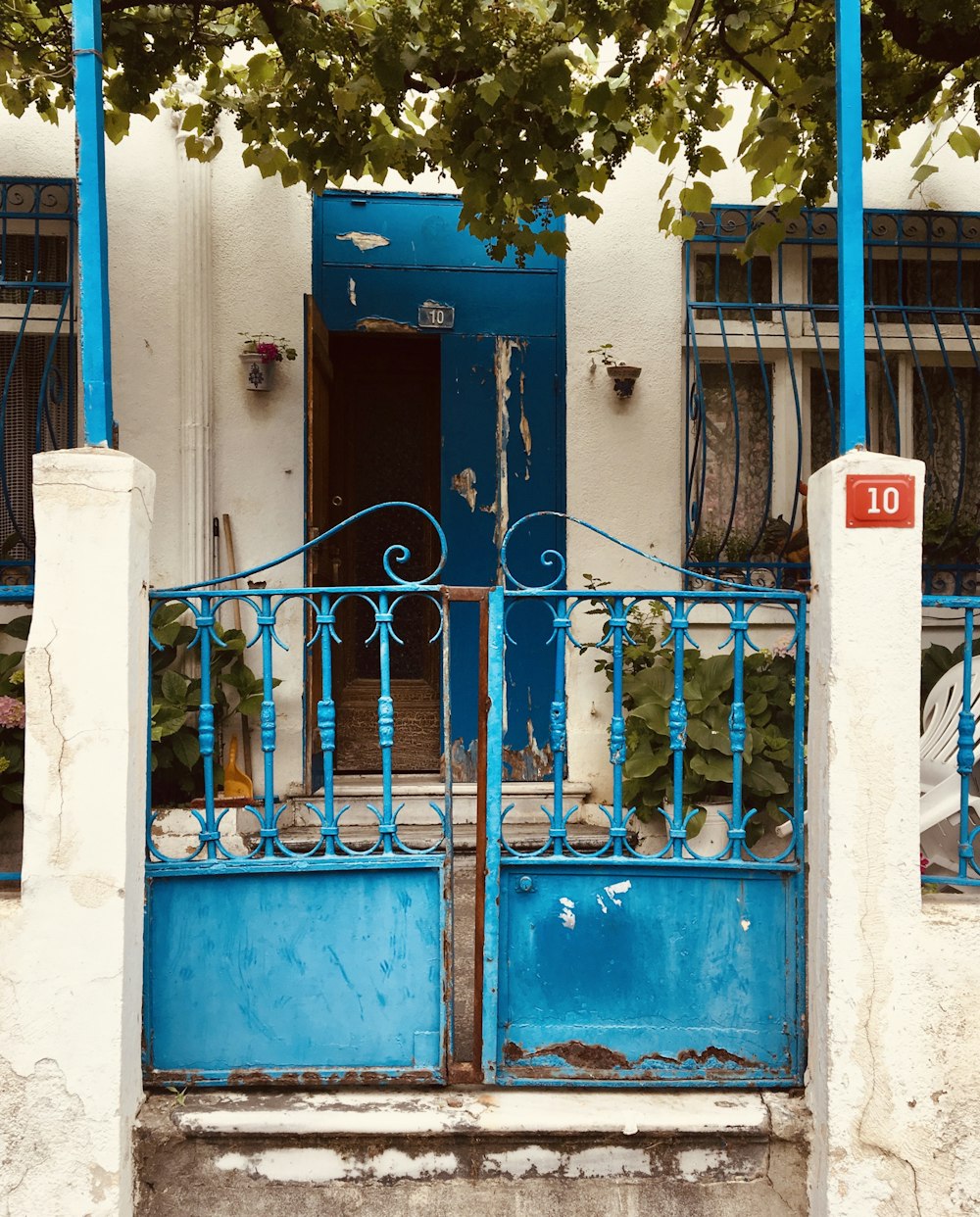 blue wooden door with blue metal fence