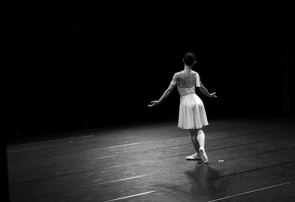 woman in white dress walking on black floor