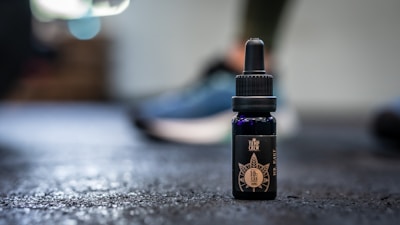 Close-up of DMSO bottle with a dropper on a natural wooden surface.