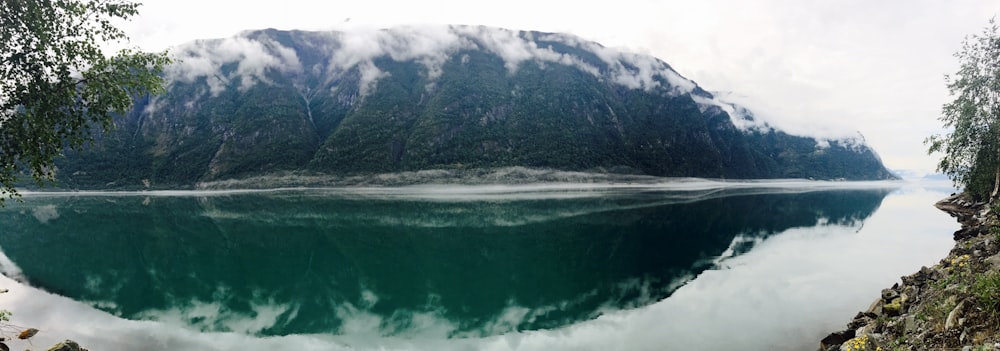 green lake near mountain during daytime