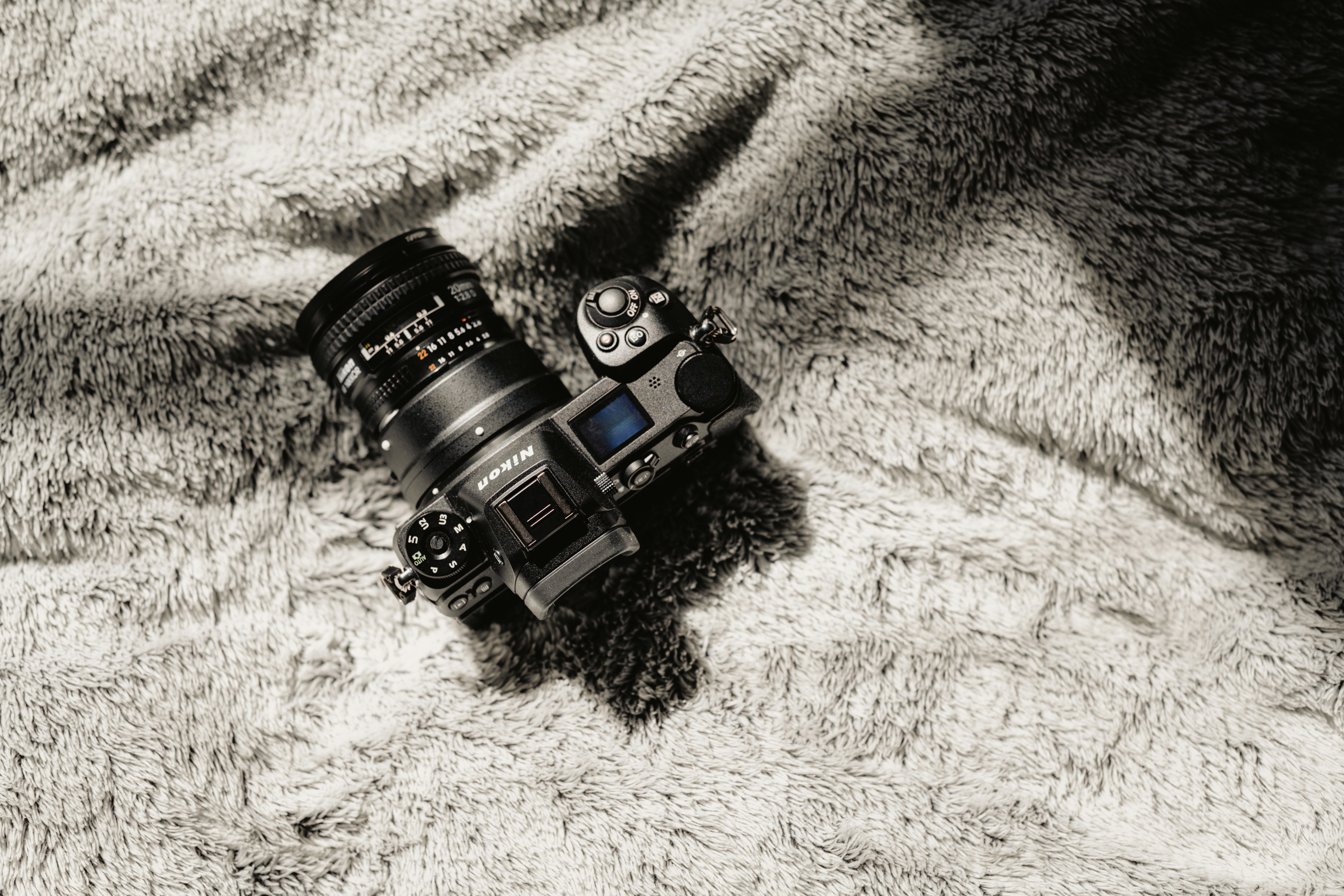 an old film camera sitting on a soft blanket
