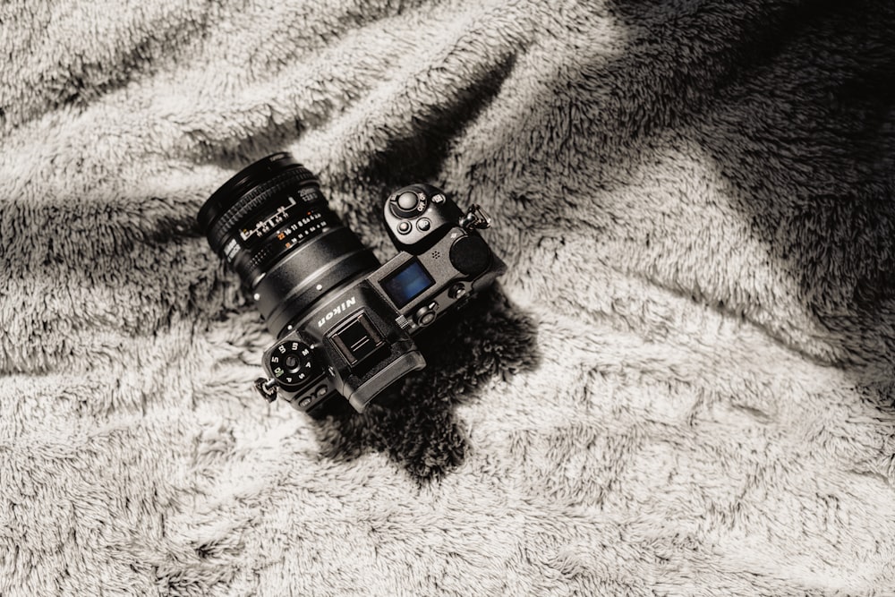 black and silver dslr camera on white textile